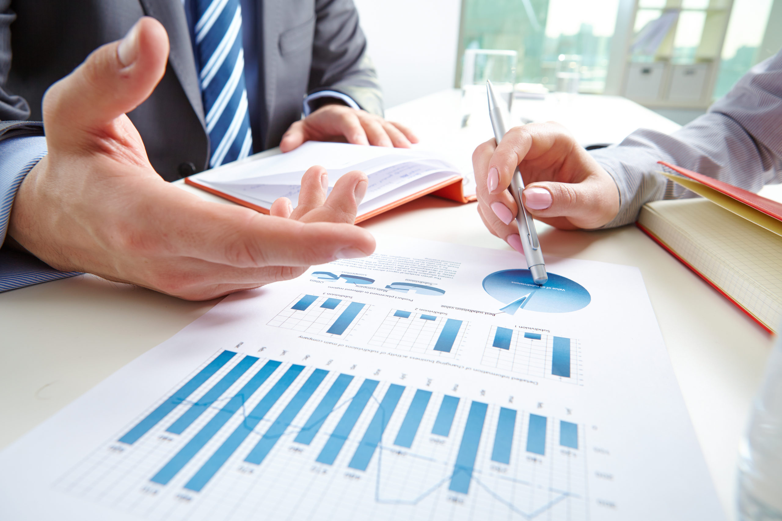 Businessman pointing at document while discussing it with colleague at meeting